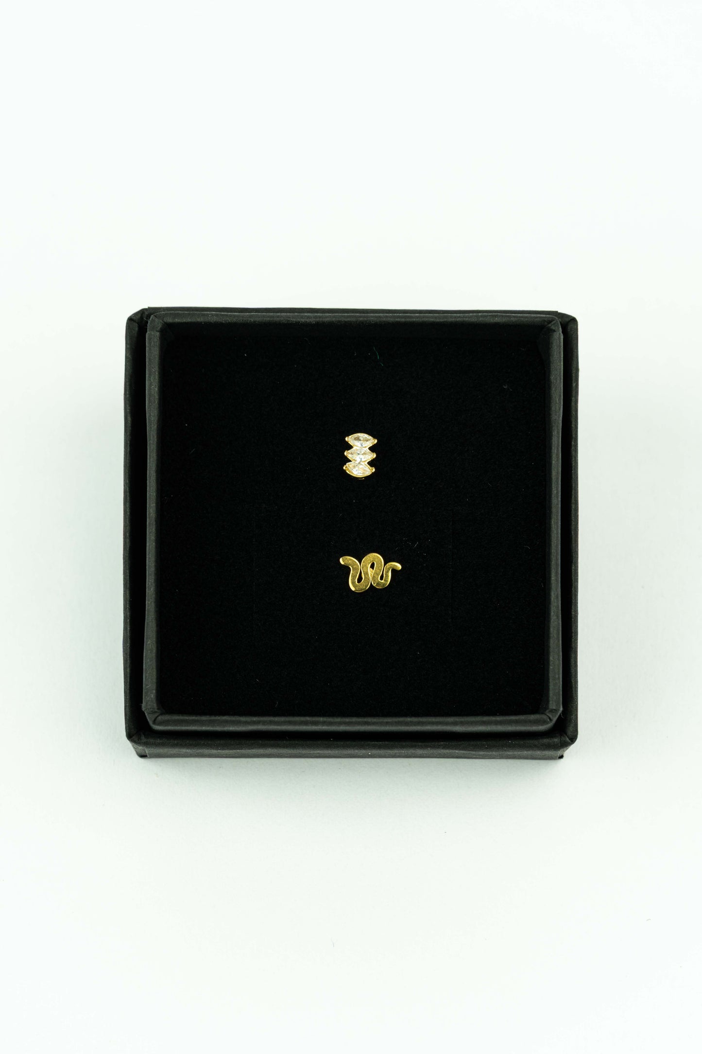 Beautiful set of 2 stud earrings.&nbsp; &nbsp;Snake inspired and trio of diamond shaped Zirkonia crystals in goldplated stainless ideal for mix &amp; match.

Handpicked by our Stay Gold Antwerp atelier in the center of the city, just next to the cathedral of Antwerp.

Hypoallergenic

Giftwrapped in a beautiful Stay Gold Antwerp box.