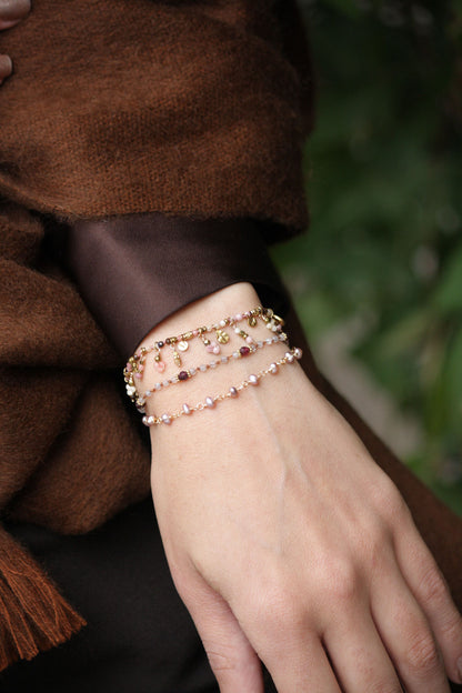 ALilac amethyst gemstone bracelet accented with deep red garnet beads and stainless steel details